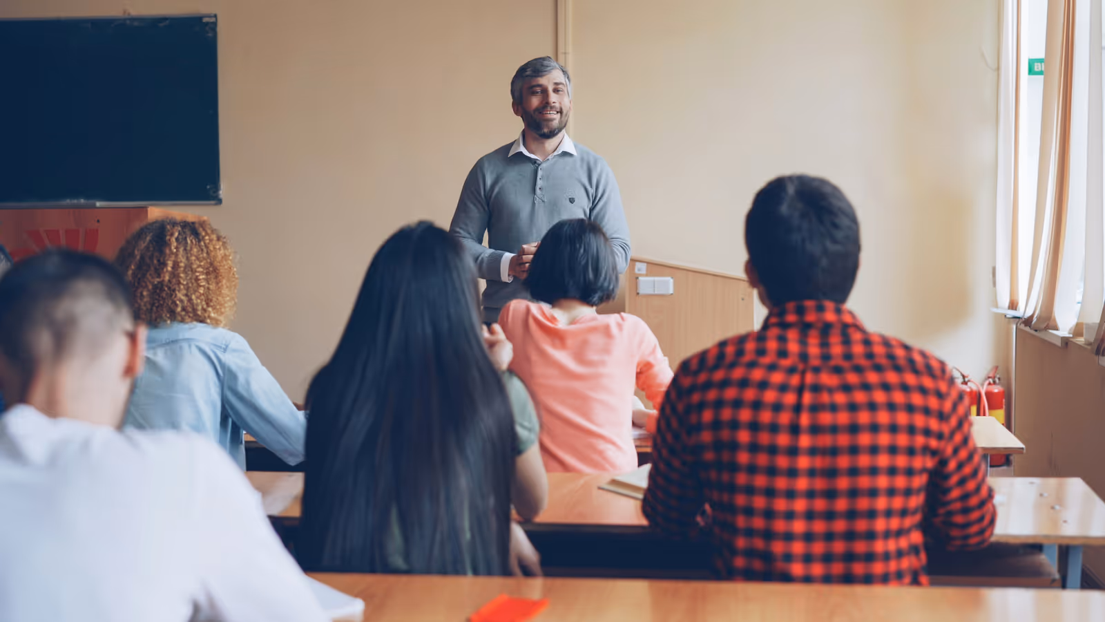 Sala de aula com alunos adolescentes sentados em carteiras, sem celulares à vista Sala de aula com alunos adolescentes sentados em carteiras, sem celulares à vista