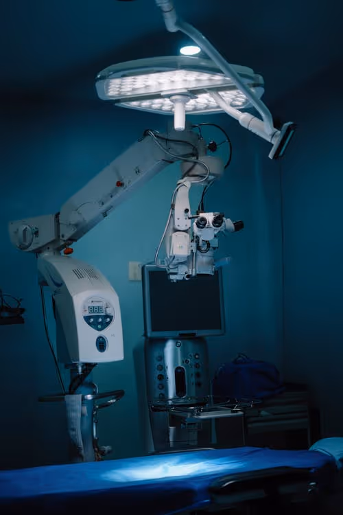 Equipamento cirúrgico robótico em sala de operações com iluminação azulada