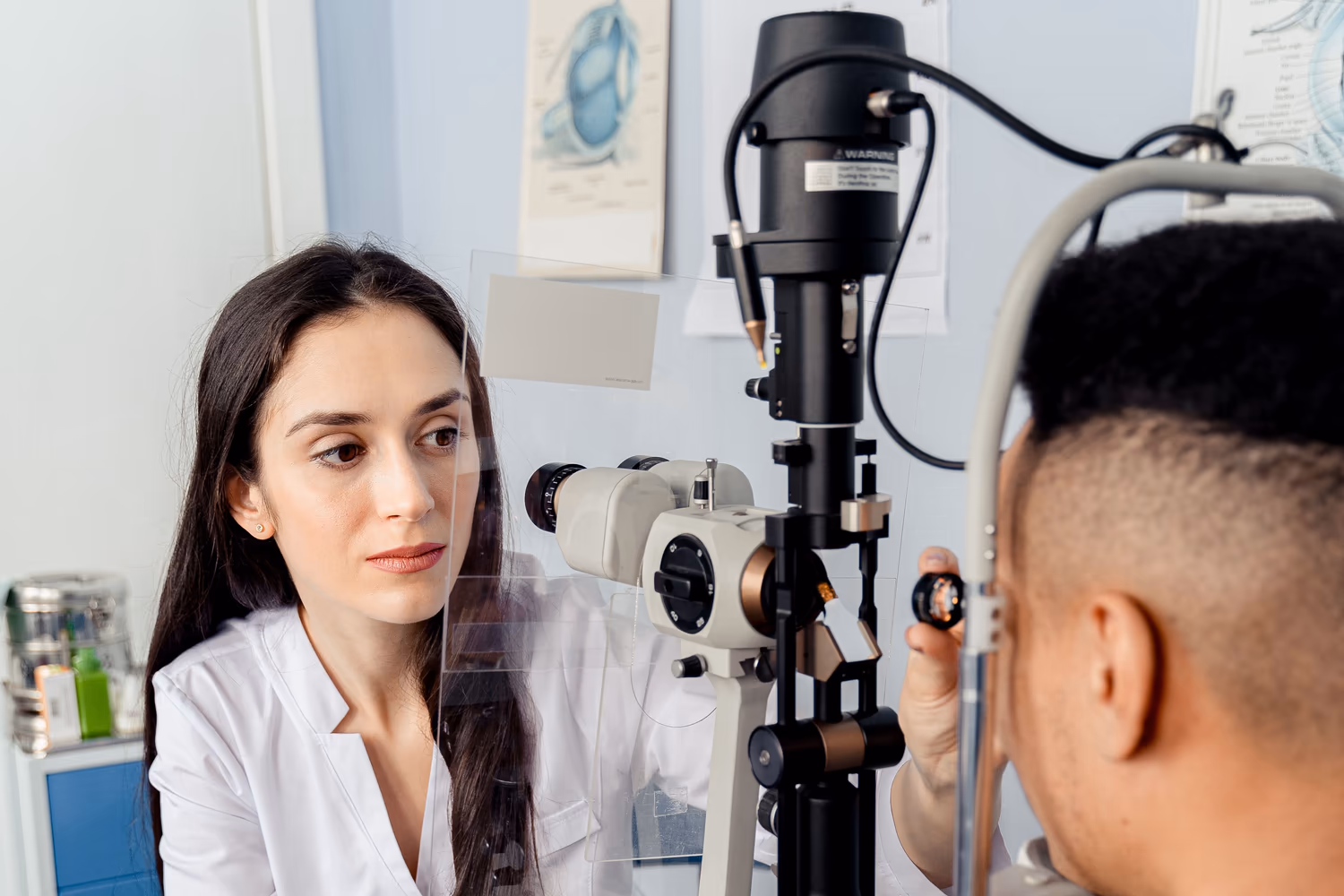 Profissional de saúde ocular examina paciente na lâmpada de fenda Profissional de saúde ocular examina paciente na lâmpada de fenda